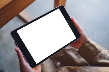 Boş beyaz masaüstü ekran ile siyah tablet bilgisayarını tutan bir kadının görüntüsü 