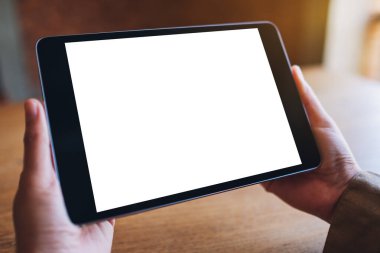 Boş beyaz masaüstü ekran ile siyah tablet bilgisayarını tutan bir kadının görüntüsü 