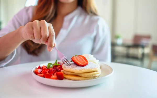 Eine Frau Hält Und Isst Pfannkuchen Mit Erdbeeren Und Schlagsahne — Stockfoto