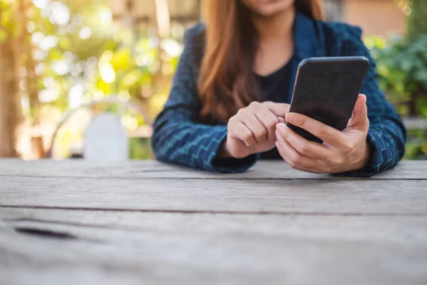 Zbliżenie Kobiety Trzymającej Używającej Patrzącej Telefon Komórkowy Zewnątrz — Zdjęcie stockowe