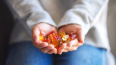 Yakından bakınca, elinde renkli jelibon ayıcıklar tutan bir kadın görülüyor.