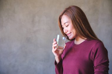 Elinde bir bardak su tutan genç bir kadının portresi.