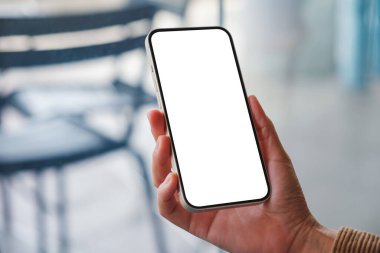 Kafede boş masaüstü ekranı olan cep telefonu tutan bir kadının görüntüsü