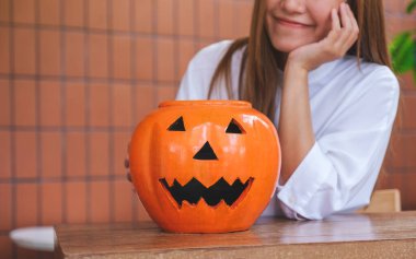 Cadılar Bayramı festivali konsepti için balkabağı kasesi olan genç bir kadının yakın plan görüntüsü.