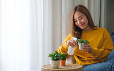 Güzel bir genç kadının portre resmi. Çiçeklerle ilgilenen ve onları sulayan bir kadın.