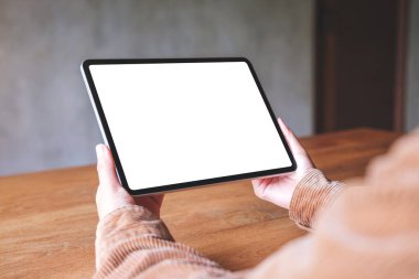 Boş beyaz masaüstü ekranlı dijital tableti tutan bir kadının görüntüsü