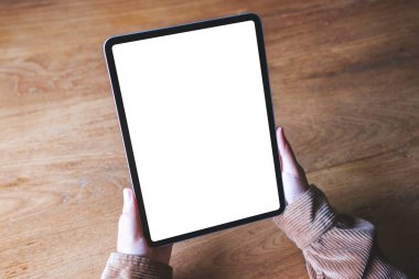 Boş beyaz masaüstü ekran ile dijital tablet tutan bir kadının en üst görünüm görüntüsü