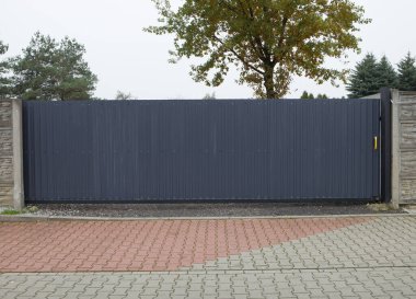 Otomatik gri sürgülü kapı - klasik metal kapı. Kapalı gri sürgülü kapı, mülke giriş..