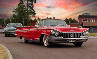 Rattvik, İsveç - 27 Temmuz 2013: Klasik Araba Haftası Rttvik - Buick Electra 225 Üstü açılabilir eski zamanlayıcı. Eski kırmızı üstü açık araba, klasik araba, günbatımı..