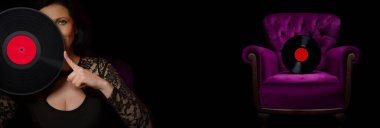 Kameraya bakıp yüzünü plakla kapatan bir kadın. Klasik bir koltukta vinil.