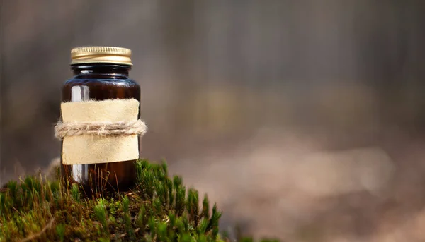 Selective focus shot of a medical bottle on green moss. Place for text