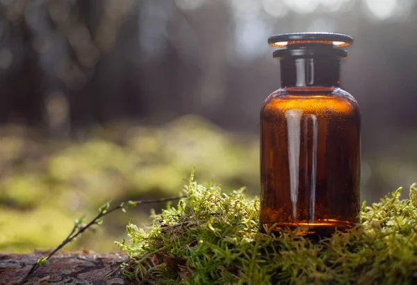 Retro medical bottle on moss with space for inscription.