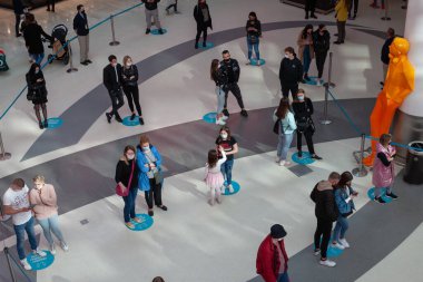 Polonya, Poznan - 08 Mayıs 2021: Alışveriş merkezindeki insanlarla arama mesafe koymak. Mesafeyi korumak için yerdeki ayak izleri. Üst görünüm