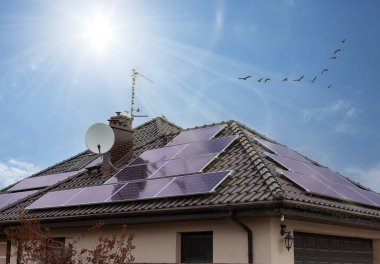 Çatıdaki güneş panelleri. Güzel, modern ev ve güneş enerjisi. Güneş ışınları. ECO GİRİŞ