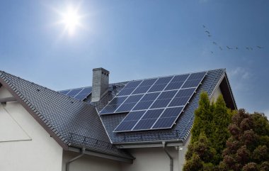 Çatı katındaki güneş panelleri. Güzel, modern ev ve güneş enerjisi. Güneş ışınları.