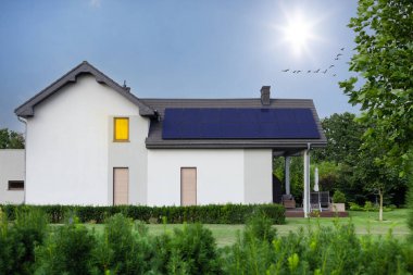 Çatıdaki güneş panelleri. Güzel, büyük modern ev ve güneş enerjisi. Mavi gökyüzü ve güneş ışınları.