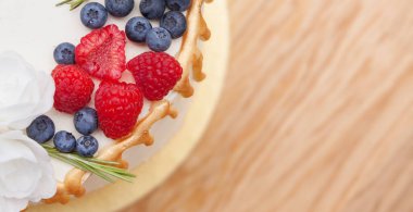 Pastanın tepesinde mesaj için yer var. Ahududu ve yaban mersinli kek.