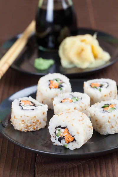 Sushi uramaki con zanahoria, pepino, surimi y blanco tostado se — Foto de Stock