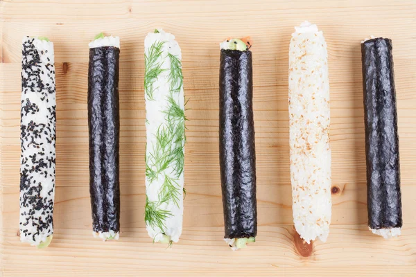 Rollos de sushi caseros en la tabla de cortar — Foto de Stock