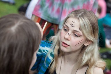 Moskova, Rusya - 1 Temmuz 2020: Güzel sarışın kız Tsaritsyno Parkı 'ndaki Hippi Günü' nde kız arkadaşıyla barışıyor. Hippi Günü her yıl Tsaritsyno Park 'ta kutlanır..