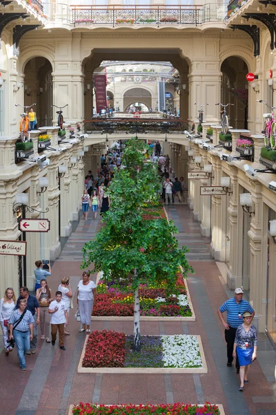 Artificial trees and walking people in GUM store — Stock Photo, Image