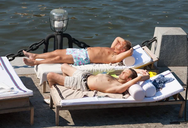 Deux hommes allongés sur des canapés et bronzant à Olive Beach — Photo