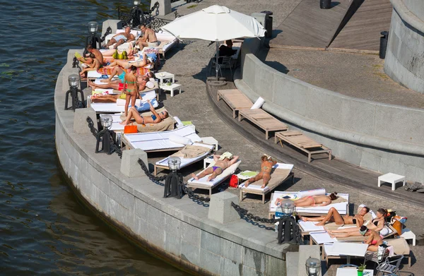 Ludzie, leżącego na kanapy i opalania na plaży z oliwek — Zdjęcie stockowe