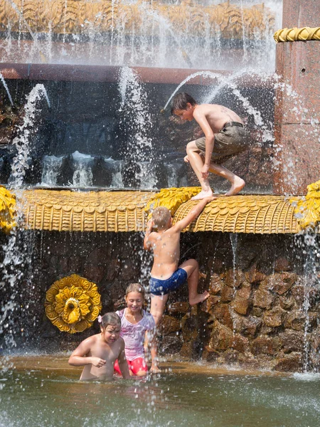 Barn bada nära en fontän — Stockfoto