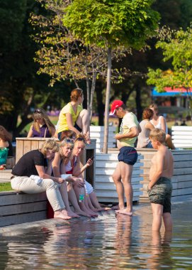 Bir su birikintisi kıyıda duran insanlar
