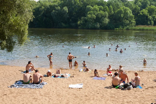 Люди загорают и купаются на пляже — стоковое фото