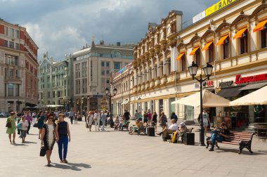 People walking and resting on benches on Kuznetsky Most Street