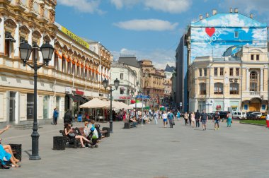 People walking and sitting on benches on Kuznetsky Most Street