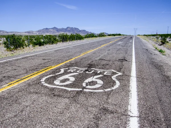 Lunga strada con un cartello Route 66 dipinto sopra — Foto Stock