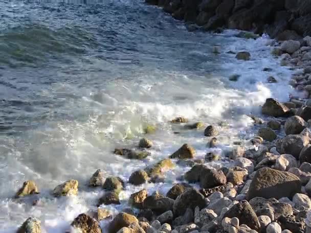 Vågor bryter på en stenig strand — Stockvideo