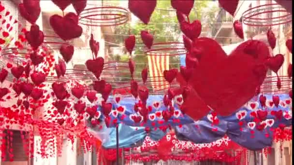 Coeurs rouges suspendus et se déplaçant dans les rues du quartier de Gracia, Barcelone — Video