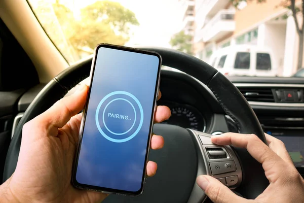 Emparelhamento Smartphone com o sistema de multimídia do carro. Usando o dispositivo de telefone móvel durante a condução. — Fotografia de Stock