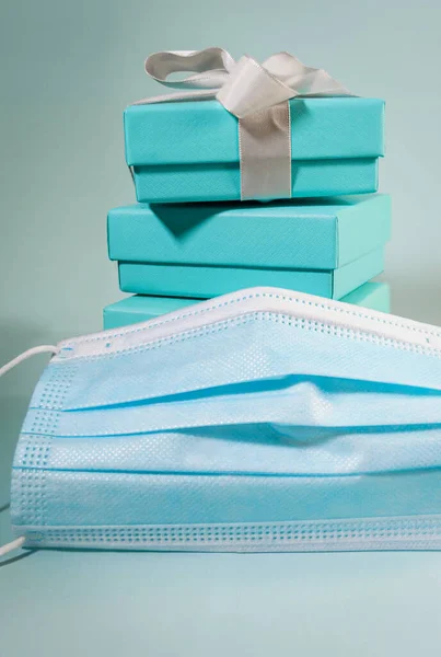 Stack of turquoise blue boxes, one tied with white silk ribbon