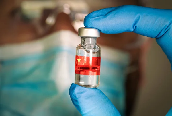 Close-up of medical vial with the Chinese flag and blurred doctor on the background. — Stock Photo, Image