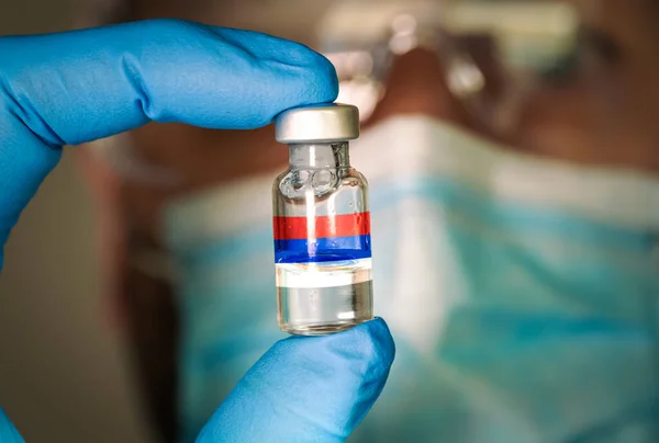 Close-up of medical vial with the russian flag and blurred doctor on the background. — Stock Photo, Image