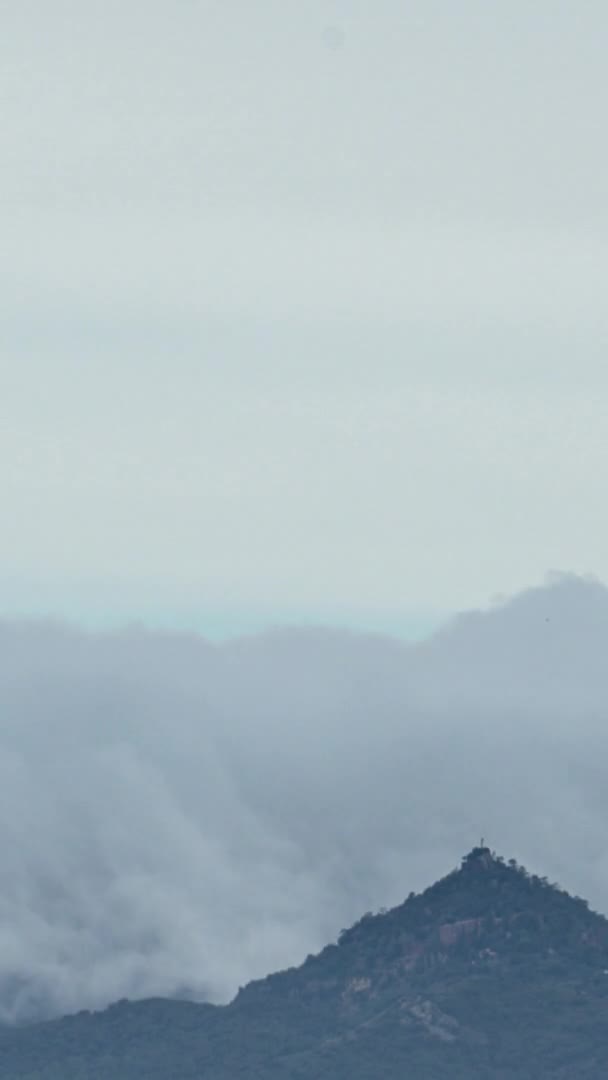 Vídeo vertical de uma nuvem em movimento e neblina sobre uma linha de montanhas timelapse — Vídeo de Stock