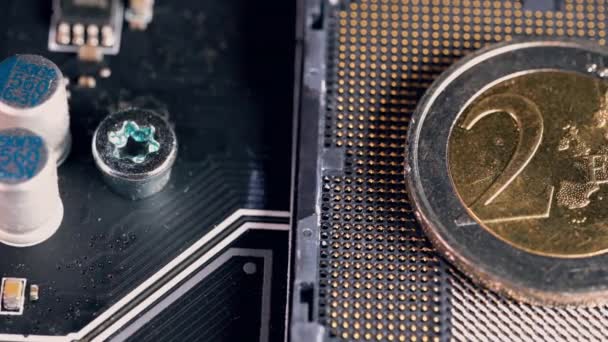 Монета в 2 евро над слотом процессора в материнской плате, символизирующим цифровой евро. — стоковое видео