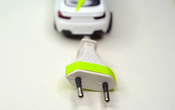 Toy car and electrical plug. Electric car and green car concept