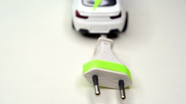 Oyuncak araba ve elektrik prizi. Elektrikli araba ve yeşil araba konsepti