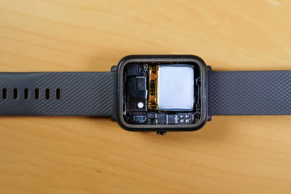 Gedemonteerd smartwatch met het interieur, batterij, verschillende sensoren en CPU. Stockfoto
