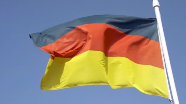 Německá vlajka vlaje proti modré obloze zpomaleným pohybem — Stock video