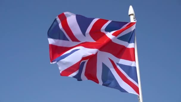 Ağır çekimde mavi gökyüzünde dalgalanan İngiliz bayrağı — Stok video