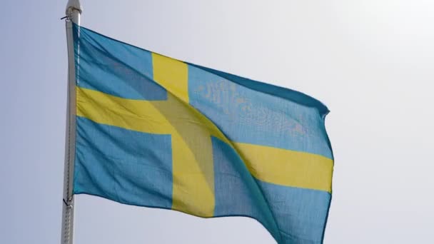 Sveriges flagga fladdrar mot blå himmel i slow motion — Stockvideo