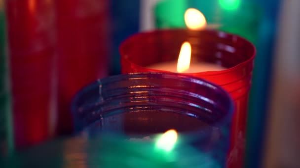 Imágenes macro de cámara lenta de velas dentro de una iglesia católica en un estante de velas — Vídeos de Stock