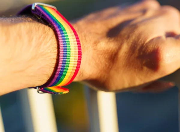 Vista de cerca de una mano de hombre con una pulsera de arco iris LGBT. — Foto de Stock