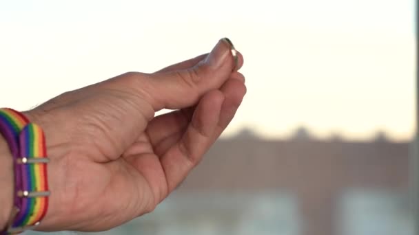 Z bliska widok męskiej dłoni pokazującej pierścień z tęczową opaską LGBT. — Wideo stockowe
